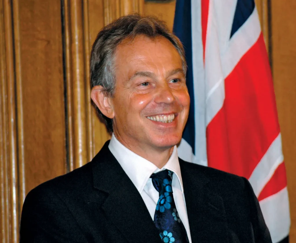 Former UK Prime Minister Tony Blair smiles in a formal setting.